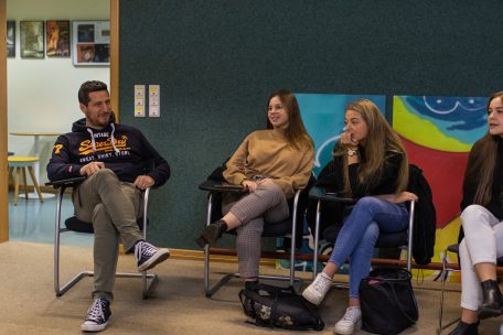 Gianni Mersch sitzt mit Schülern vom Uelzechtkanal in einer Runde