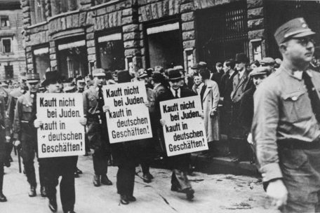 Jüdische Geschäftsleute werden genötigt, gegen sich selbst zu werben. Leipzig, Brühl Straße, 1937
