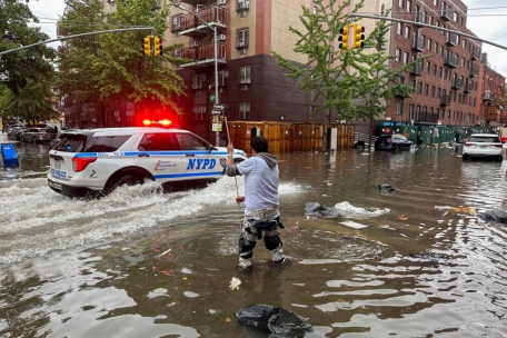 Ein Mann versucht im Stadtbezirk Brooklyn einen Abfluss im Hochwasser zu reinigen