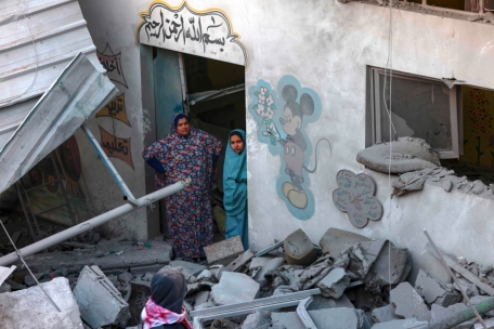 Eine Frau und ein Kind stehen inmitten der Trümmer eines von israelischen Bomben getroffenen Kindergartens in Rafah im südlichen Gazastreifen am 9. Dezember 2023, inmitten anhaltender Kämpfe zwischen Israel und der militanten Gruppe Hamas. Israel setzte seine Offensive gegen die Hamas-Kämpfer im Gazastreifen am 9. Dezember fort.