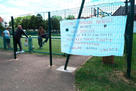 Ein Banner an einem angrenzenden Fußballplatz klärt interessierte Passanten über das Ziel des Picknicks auf