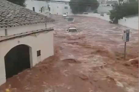 Braune Wassermassen fließen zwischen den Häusern bei schwerem Unwetter